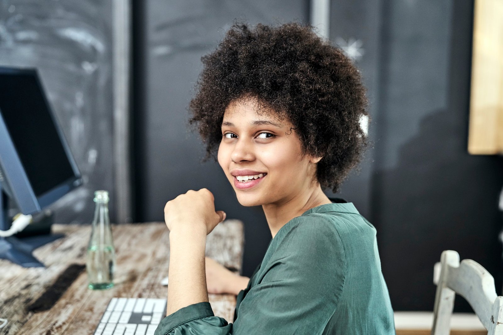 Portrait of smiling young woman at wooden table in office